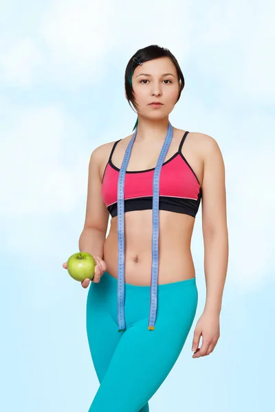 健身女孩厘米磁带和苹果在蓝天背景 — 图库照片