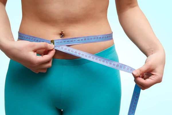 Fitness Meisje Taille Meten Met Een Centimeter Een Blauwe Achtergrond — Stockfoto