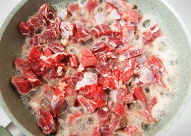 kırmızı et bir tavada kızartılıyor. yakın çekim