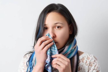 Onun burnu dokusuyla esen soğuk olan kadın. Asyalı güzel kız portresi gribi hapşırma hasta olsun. Sağlık ve tıp kavramı.