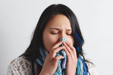 Onun burnu dokusuyla esen soğuk olan kadın. Asyalı güzel kız portresi gribi hapşırma hasta olsun. Sağlık ve tıp kavramı.