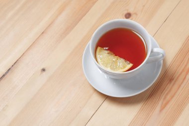 Ahşap masa üzerinde limonlu çay fincan