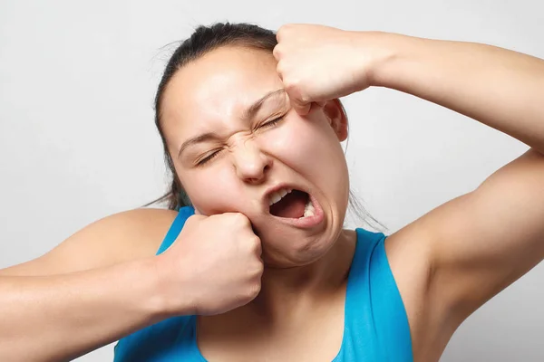 Young woman showing how can take a punch leaning fist to her face