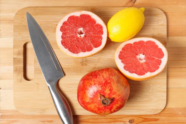 limon, greyfurt, nar kesilmiş bambu ahşap tahta üzerine şeklinde