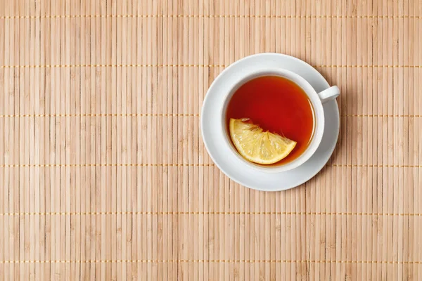 ahşap yüzey zemin üzerine beyaz fincan limonlu çay