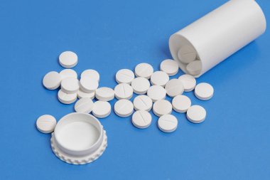 Beyaz daire tabletler ve tabletler üzerinde mavi arka plan için plastik şişe