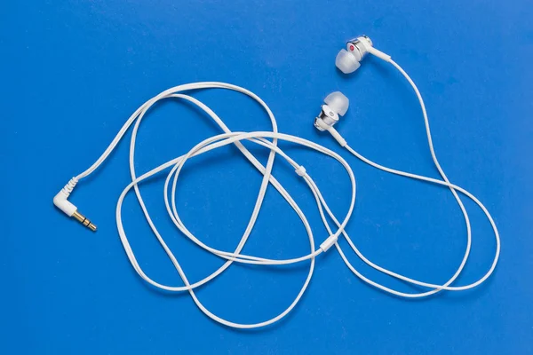 ear buds or earphones on blue color background