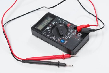Elektrik donatımı ve elektrik devreleri kontrol etmek için bir araç. Beyaz arka plan üzerinde dijital multimetre.