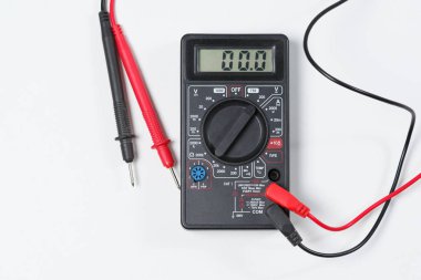 Elektrik donatımı ve elektrik devreleri kontrol etmek için bir araç. Beyaz arka plan üzerinde dijital multimetre.