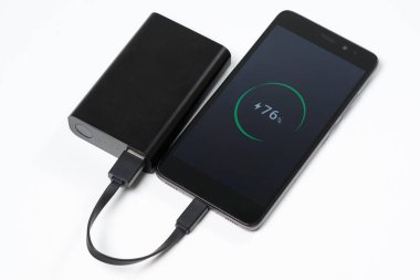 Smartphone siyah pil güç bankadan şarj oluyor.