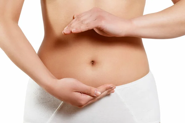 Close up cropped photo of beautiful woman's slim stomach, using hands she is showing a balance. The concept of healthy eating, diet. Early pregnancy. isolated on white — Stock Photo, Image