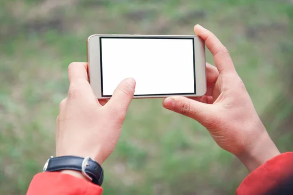 hand is holding horizontal smartphone for show and touch with white screen is outdoor