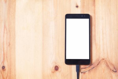 Aktarmak için akıllı telefon ve veri bağlantı kablosunu kapatın ve teknoloji konsepti için ahşap zemin arka plan ve doku kullanımı nda pili şarj edin