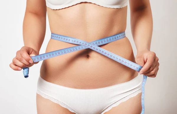 Femme mesurant son corps mince sur fond blanc — Photo