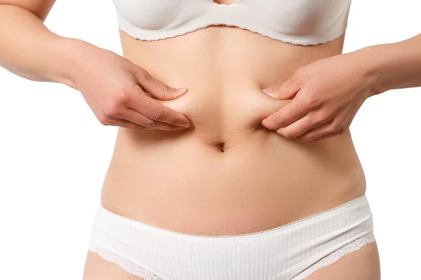 Пальцы женщины измеряют ее жир в животе, изолированные на белом фоне — стоковое фото