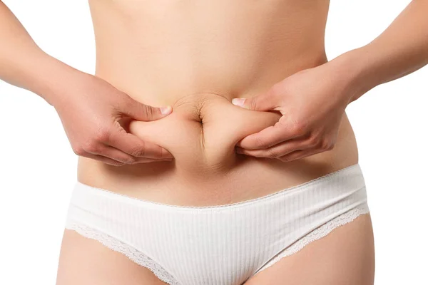 Kadının göbek yağlarını ölçen parmakları, beyaz sırtında izole edilmiş.