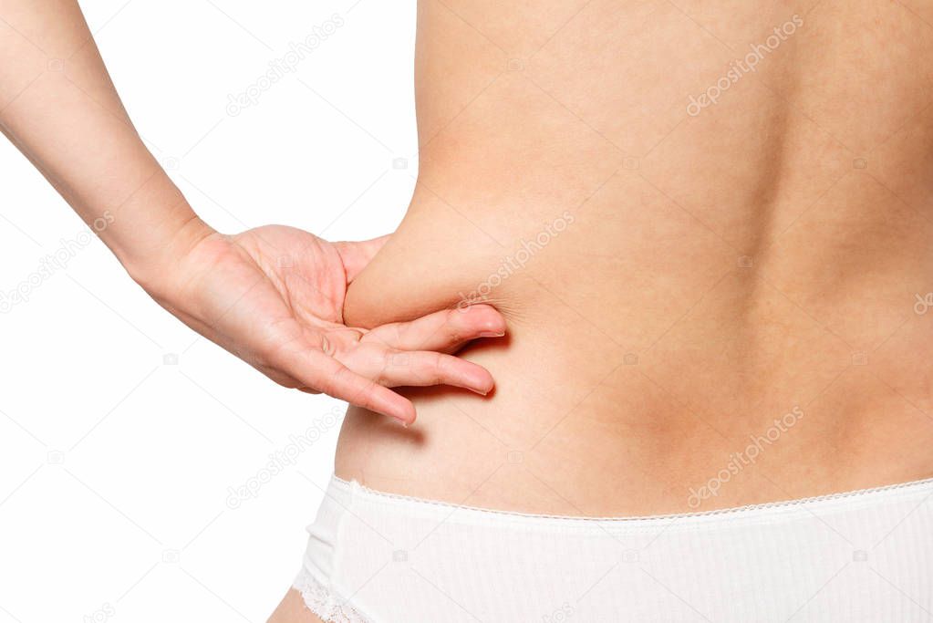 woman in white underwear takes extra fat on the sides of her stomach with her hand. isolate on white background