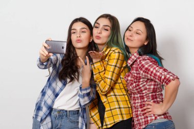 Üç neşeli kız kız selfie yapıyor. Gülümse -yen. beyaz arka planda