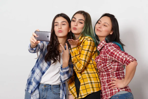 Τρία χαρούμενα κορίτσια κοπέλες κάνουν selfie. Χαμογελώντας. σε λευκό φόντο — Φωτογραφία Αρχείου