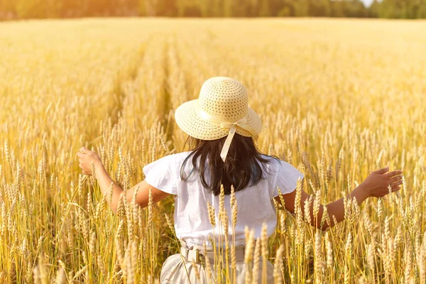 Mujer feliz con un vestido volador y un sombrero en un campo de trigo. Libertad, concepto de alegría . —  Fotos de Stock