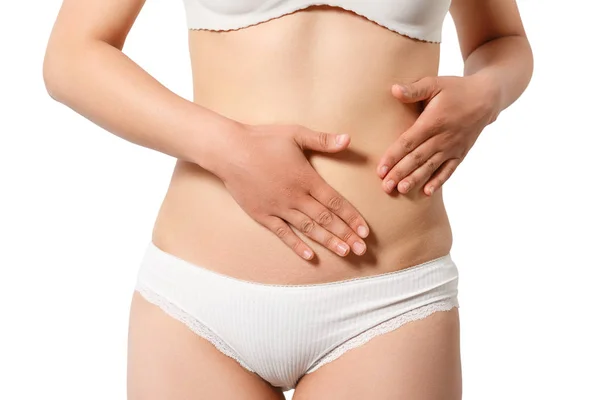 Gebeliğin erken dönem kavramı. Kadının karın ve göbek deliği yakın fotoğraf, o iki eliyle onu ince mide dokunuyor. izole beyaz arka plan