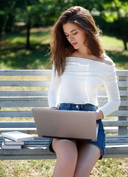 女人坐在公园的长椅上 用笔记本电脑 — 图库照片