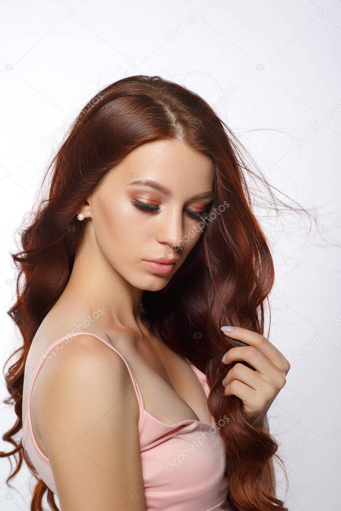 portrait of a red-haired beautiful young woman on a light background