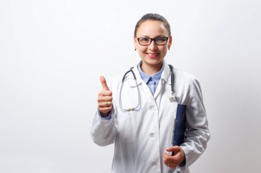 Beyaz bir arka planda genç bir kadın doktorun portresi. başparmak hareketi