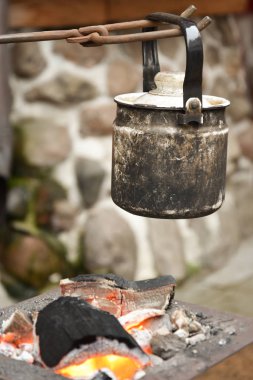 su ısıtıcısı közler üzerinde askıya alınır. Kamp.