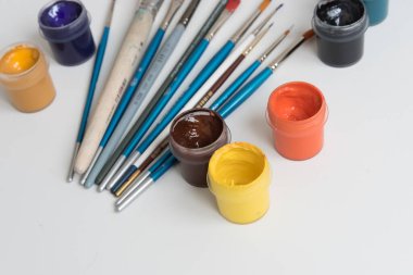 Gulajlı kavanozlar ve farklı boylarda boya fırçaları. Yukarıdan manzara. Arka plan, doku. Yaratıcılık için alan kavramı