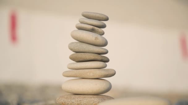 Le processus de construction d'une pyramide de pierres. Une main en gros plan place la pierre supérieure sur le dessus de la pyramide. Rayons du soleil couchant. Le concept de calme.