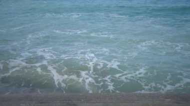 Deniz dalgaları setin basamaklarında kırılır. Üst görünüm, mavi gölgeler.