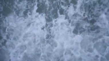 Sahildeki dalgalar, yukarıdaki manzara. Kapatın. Mavi renk.