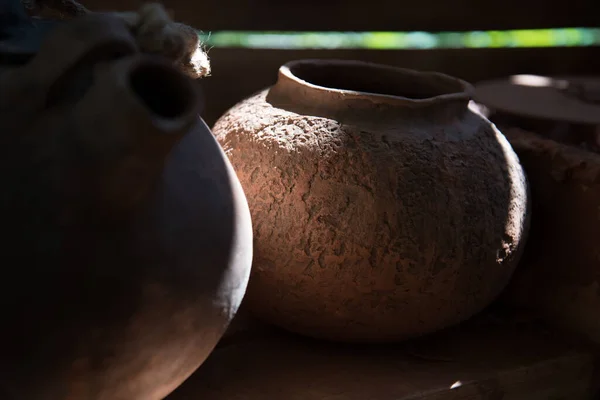 In the pottery shop, the suns rays fall on the pottery. A clay pot and a jug. The natural pattern on the clay. Background, texture. — Stock Photo, Image