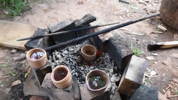 Vasos de barro están cerca de las brasas ardientes del fuego. Té caliente fragante. Senderismo en la naturaleza. Relajarse y disfrutar del té en la naturaleza. — Vídeo de stock