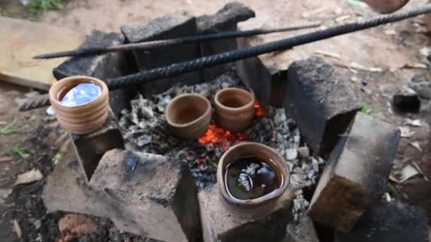 Kubki ceramiczne stoją w pobliżu płonących żarów ognia. Pachnąca gorąca herbata. Wędrówki w przyrodzie. Relaks i cieszyć się herbatą w przyrodzie. — Wideo stockowe