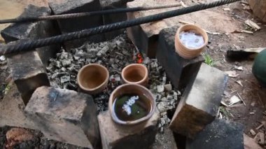 Dumanı tüten bir çaydanlık ve çay fincanı. Kil tencerede ateşte çay hazırlamak. Kamp gezisi, yolculuk..