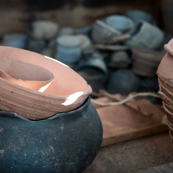 In the pottery shop, the suns rays fall on the pottery. A clay pot and a jug. The natural pattern on the clay. Background, texture. — Stock Photo, Image