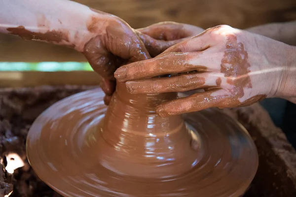 Pottern lär barnet att arbeta på Potters hjul. Händerna på nära håll. Arbete med lera, handgjort. — Stockfoto