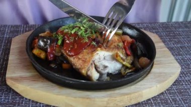 Sebzeli kızarmış tavuk. Öğle yemeği süreci. Bıçak tabağı keser..