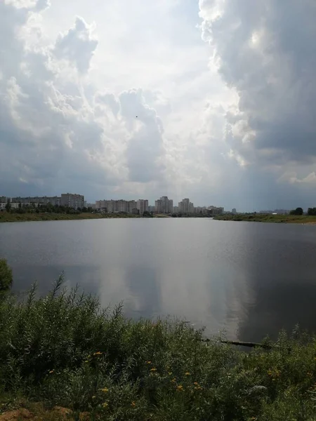 Şehirde yağmurdan önce bulutlu bir gökyüzü. Şehirdeki göl.