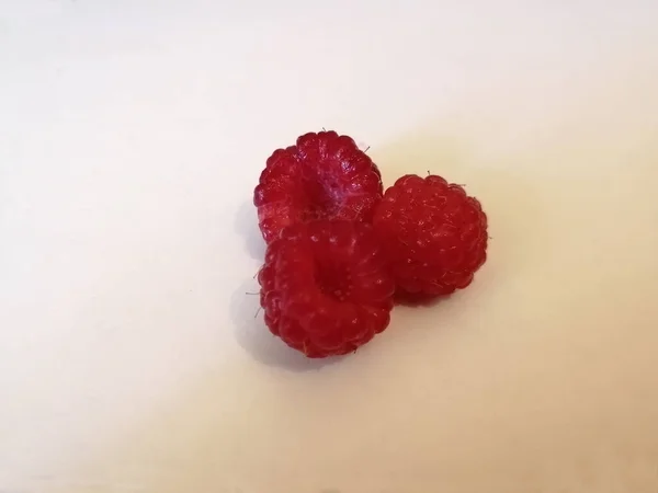 Bir parça kağıt üzerinde taze ahududu. Üç parça..