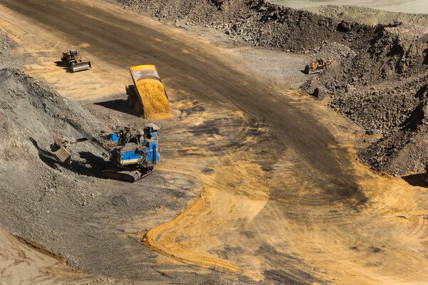 An open pit diamond mine in Botswana with heavy machinery on site.
