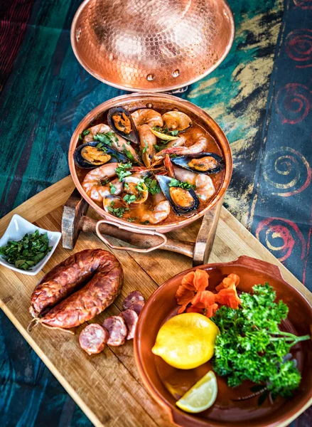 Masanın üzerinde bir cataplana tencerede istiridye ile geleneksel Portekiz ameijoas hizmet