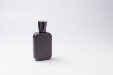 Beyaz arka planda siyah parfüm şişesi