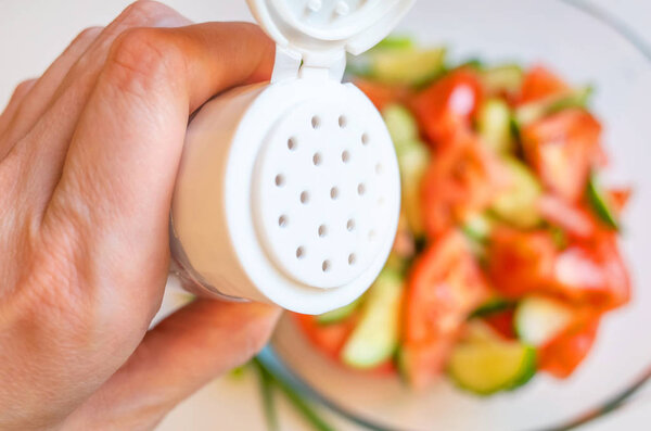 Свежий овощной салат из помидоров и огурцов и солонки, образ подходит для предмета здорового органического питания
.