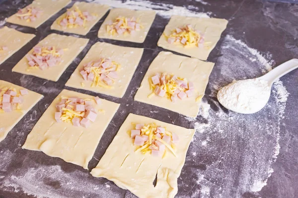 Blätterteig Mit Schinken Und Käse Liegen Auf Einem Dunklen Küchentisch — Stockfoto