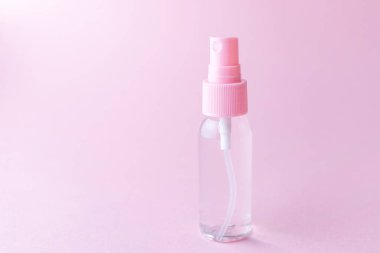 Pastel pembe arka planda şeffaf losyonlu kozmetik şişesi. Kozmetik, cilt bakımı, güzellik ve sağlık. Minimalizm, metin için yer.