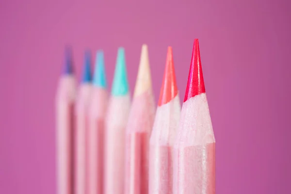 Colored pencils of rainbow colors close-up in a trendy neon light. The concept of artistic accessories, creativity. Place for text, minimalism.