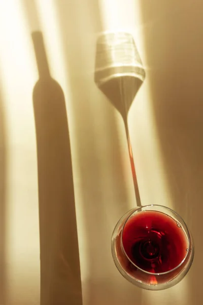 Szklanka Czerwonego Wina Jasnym Tle Spektakularny Długi Cień Spada Szklanki — Zdjęcie stockowe